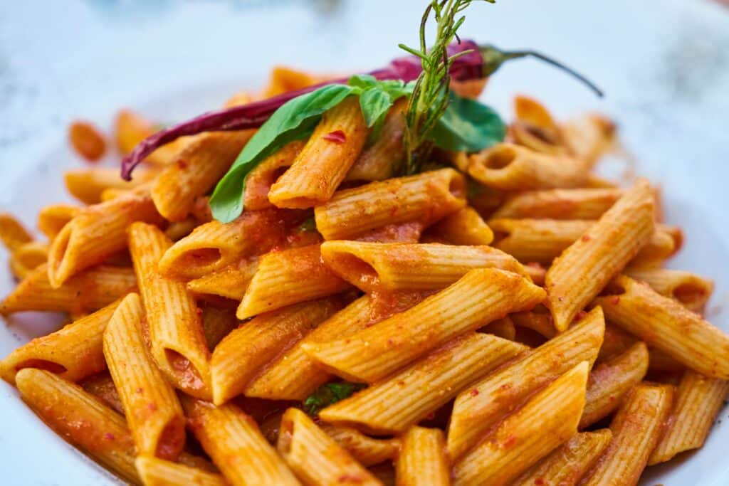 A close-up shot of a bowl of creamy tomato pasta, garnished with parmesan and basil. The rich, pink sauce coats the fettuccine perfectly, showcasing an easy and delicious recipe.